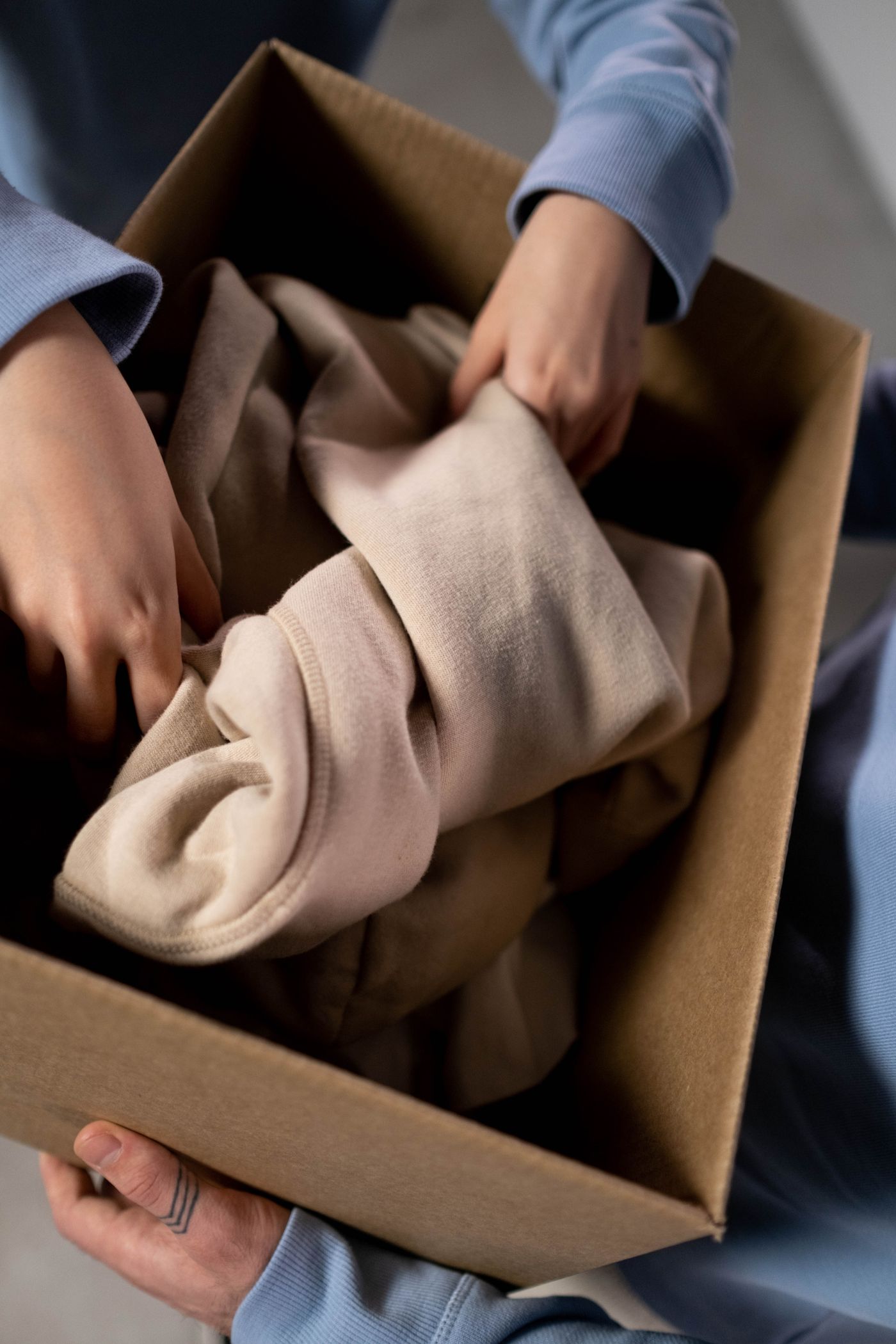 A person holding a parcel with clothing.